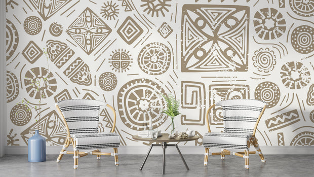 Modern tribal geometric wall mural in gold and white with abstract patterns, styled in contemporary living room with two chairs.