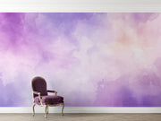 Watercolour wall mural in soothing purple and pastel tones, featuring a classic purple velvet chair in a minimalist room.