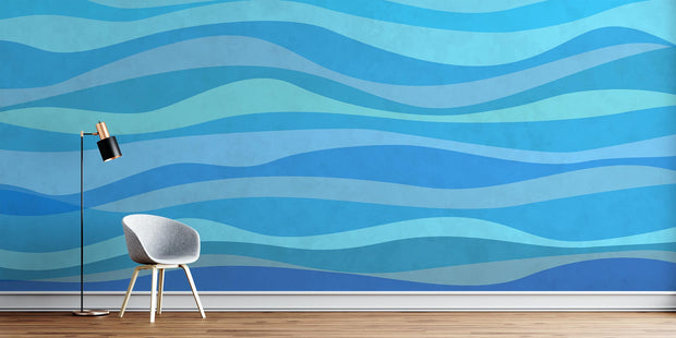 Modern blue wave wall mural featuring abstract wave patterns in various shades of blue, enhancing the decor of a living room.