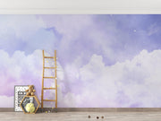 Dreamy cloud-themed wall mural with soft purple hues and fluffy white clouds, decorating a modern children's room with cozy accents, toys.