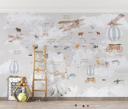 Whimsical world map wall mural featuring illustrated continents, animals, vintage airplanes, and hot air balloons, styled in a modern kids' room.