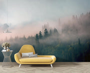 Forest wall mural with morning fog, evergreen trees, and soft pink hues; decorating a living room.