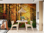 Golden autumn wall mural with a forest path surrounded by vibrant fall foliage and sunlit trees, decorating a dinning room.