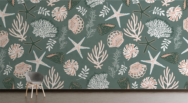 Coastal wall mural featuring starfish, seashells, coral reefs, and marine plants in soft pastel tones on a muted green background, decorating a living room.