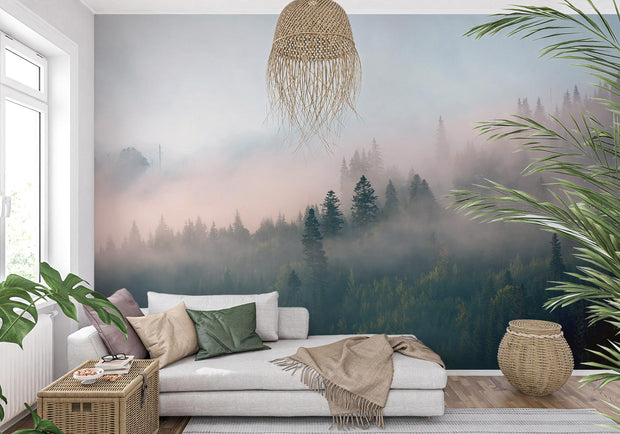 Forest wall mural with morning fog, evergreen trees, and soft pink hues, creating a serene and calming atmosphere for a cozy living room