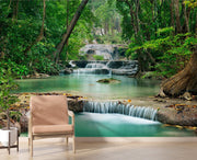 Wall mural of a lush green forest with cascading waterfalls, creating a peaceful ambiance in a modern room.