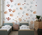 Minimalist dinosaur tracks wall mural with neutral-toned footprints decorating a stylish kid's bedroom with twin beds and wooden furniture.