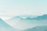 Serene misty mountain wall mural with soft blue gradient layers, creating a peaceful atmosphere.