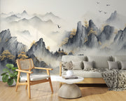 A tranquil living room featuring a Tranquil Peaks Wall Mural with misty watercolour mountains and golden foliage. Styled with wooden furniture and lush plants, creating a serene and nature-inspired atmosphere.