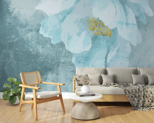 A modern living room with a Blue Floral Watercolor Wall Mural, featuring a delicate oversized flower in teal and gold hues. Creating a cosy and elegant space with a soft, artistic ambience.