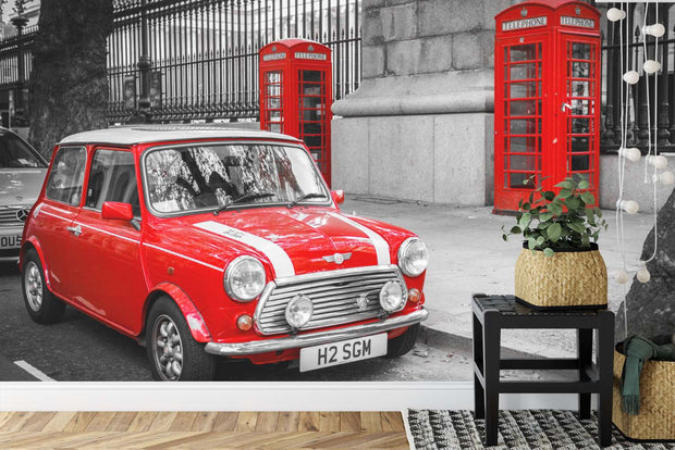 Wall mural showcasing a vibrant red Mini Cooper and iconic red telephone boxes in a black-and-white London city scene.