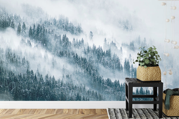 Snowy forest wall mural featuring a serene winter landscape with evergreen trees, snow, and soft mist, perfect for peaceful living room decor.