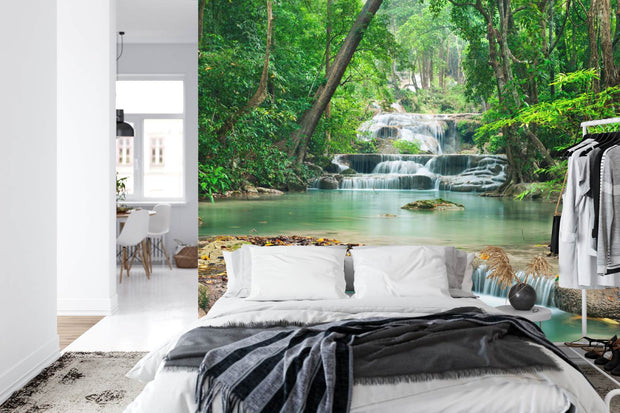 Wall mural of a lush green forest with cascading waterfalls, creating a peaceful ambiance in a modern room.