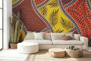 Bold tropical wall mural with vibrant orange, yellow, and brown leaf patterns, accented with white dots, perfect for boho and eclectic interior decor.