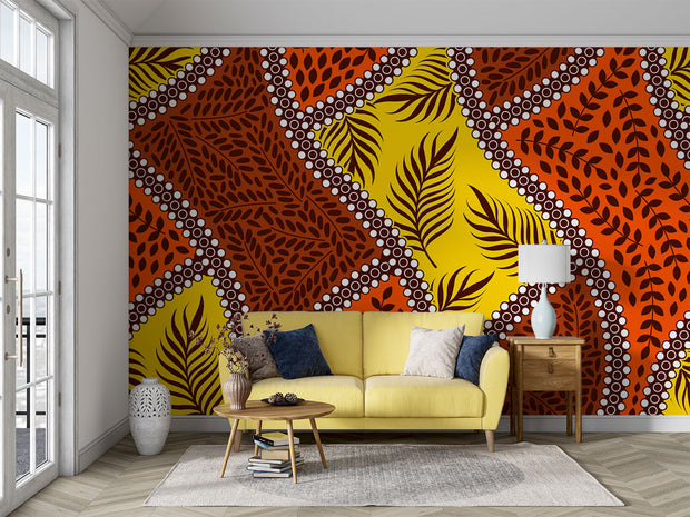 Bold tropical wall mural with vibrant orange, yellow, and brown leaf patterns, accented with white dots, perfect for boho and eclectic interior decor.