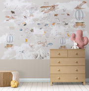 Whimsical world map wall mural featuring illustrated continents, animals, vintage airplanes, and hot air balloons, styled in a nursery.