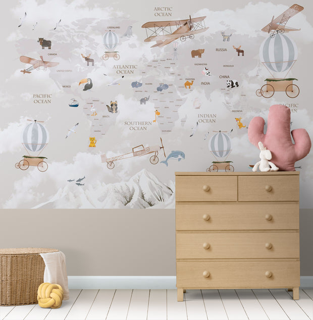 Whimsical world map wall mural featuring illustrated continents, animals, vintage airplanes, and hot air balloons, styled in a nursery.