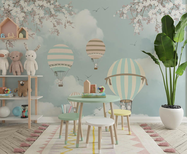 Kids' room with pastel hot air balloon wall mural featuring clouds, cherry blossoms.