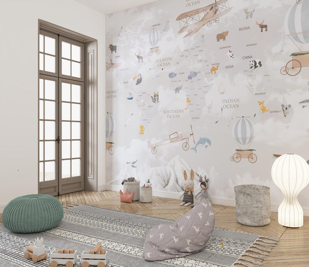 Whimsical world map wall mural featuring illustrated continents, animals, vintage airplanes, and hot air balloons, styled in a modern kids' room.